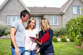 Real Estate agent woman near new house. Home for sale concept.
